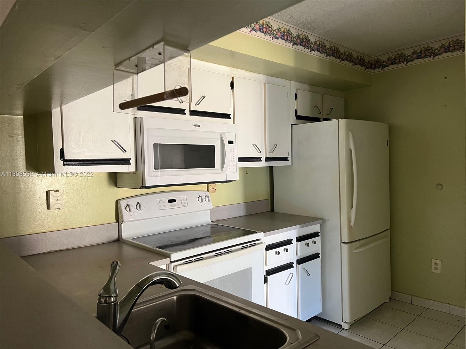 18230 Mediterranean Boulevard, Unit 113 Hialeah, FL 33015 - Photo 11 of 18 a kitchen with stainless steel appliances a refrigerator and a stove top oven