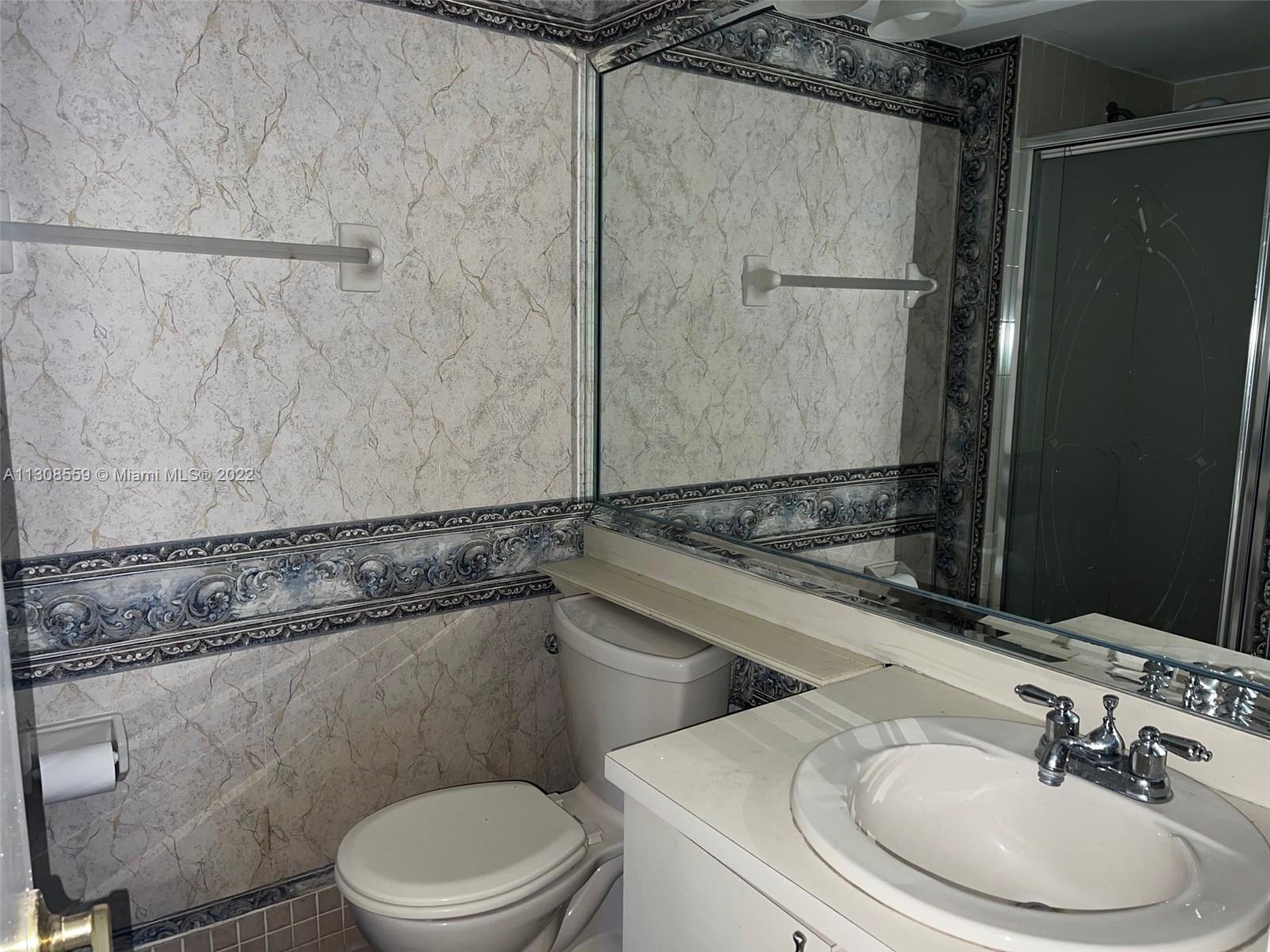 18230 Mediterranean Boulevard, Unit 113 Hialeah, FL 33015 - Photo 13 of 18 a bathroom with a sink a toilet a shower and a mirror