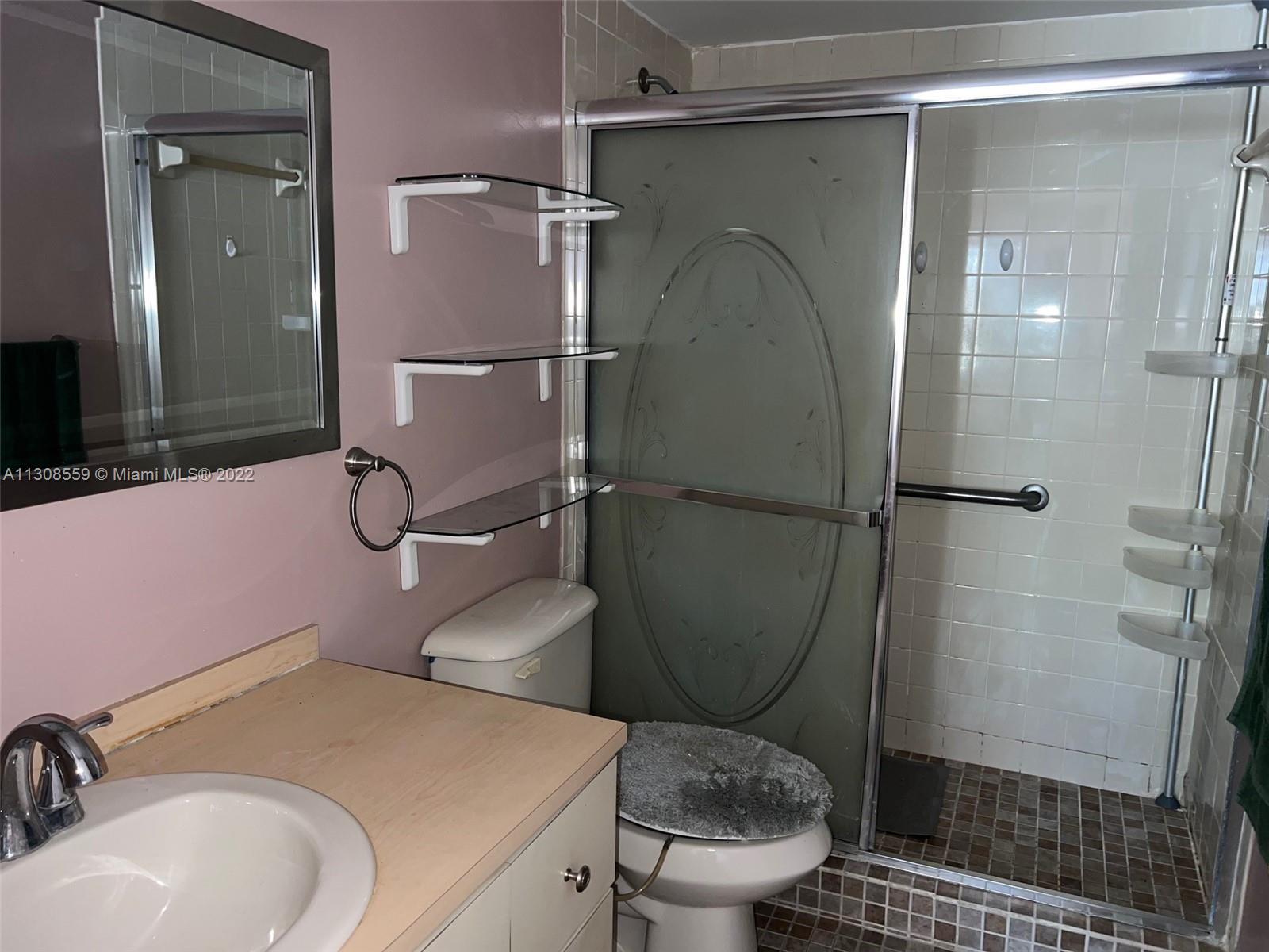 18230 Mediterranean Boulevard, Unit 113 Hialeah, FL 33015 - Photo 18 of 18 a bathroom with a sink toilet and shower