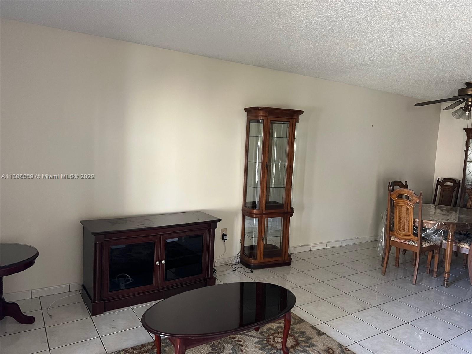 18230 Mediterranean Boulevard, Unit 113 Hialeah, FL 33015 - Photo 4 of 18 a living room with furniture a rug and a fireplace