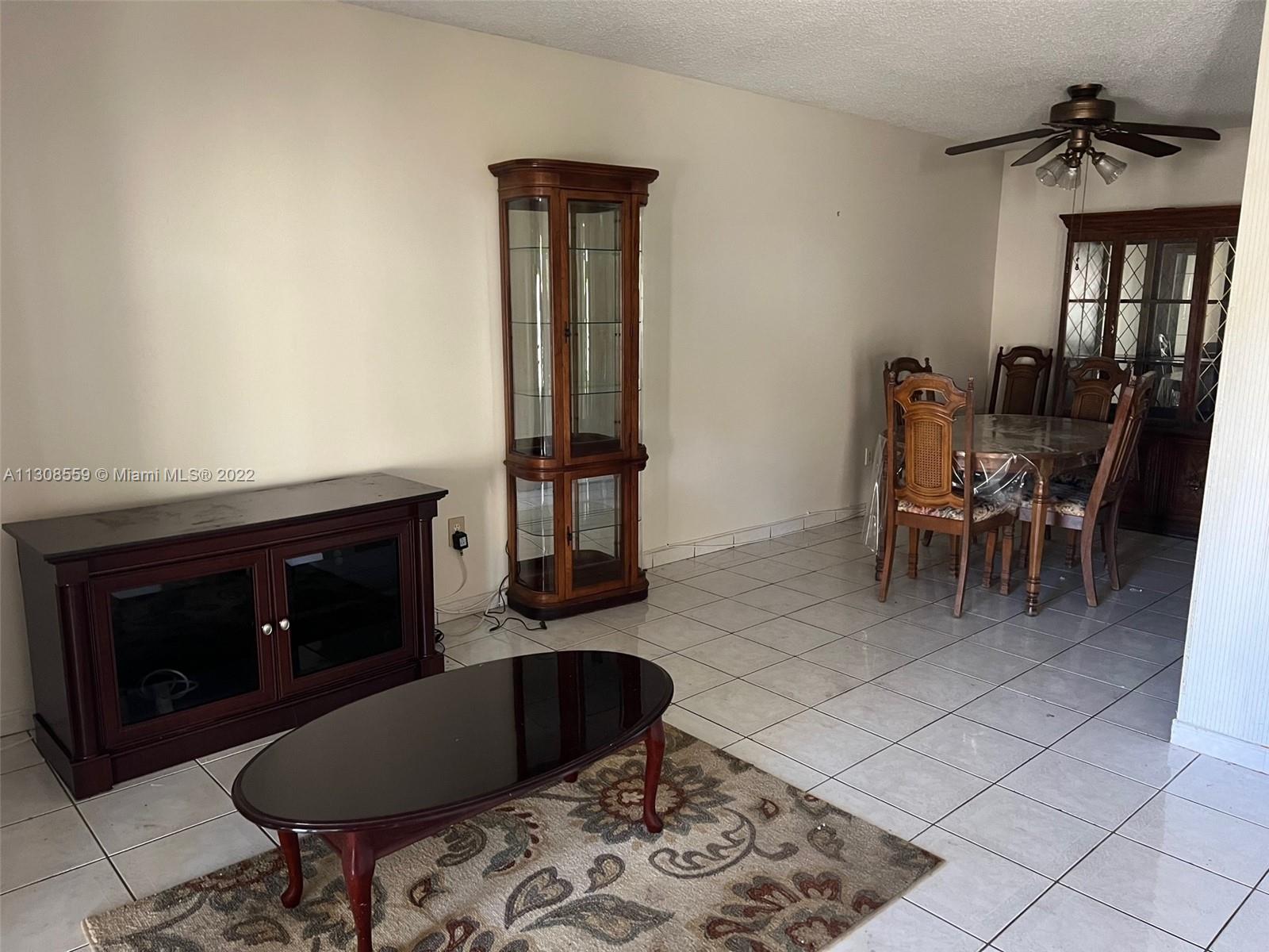 18230 Mediterranean Boulevard, Unit 113 Hialeah, FL 33015 - Photo 8 of 18 a living room with furniture a dining table and a fireplace