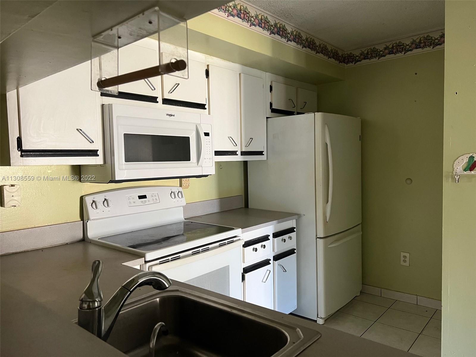 18230 Mediterranean Boulevard, Unit 113 Hialeah, FL 33015 - Photo 10 of 18 a kitchen with stainless steel appliances a refrigerator and a microwave