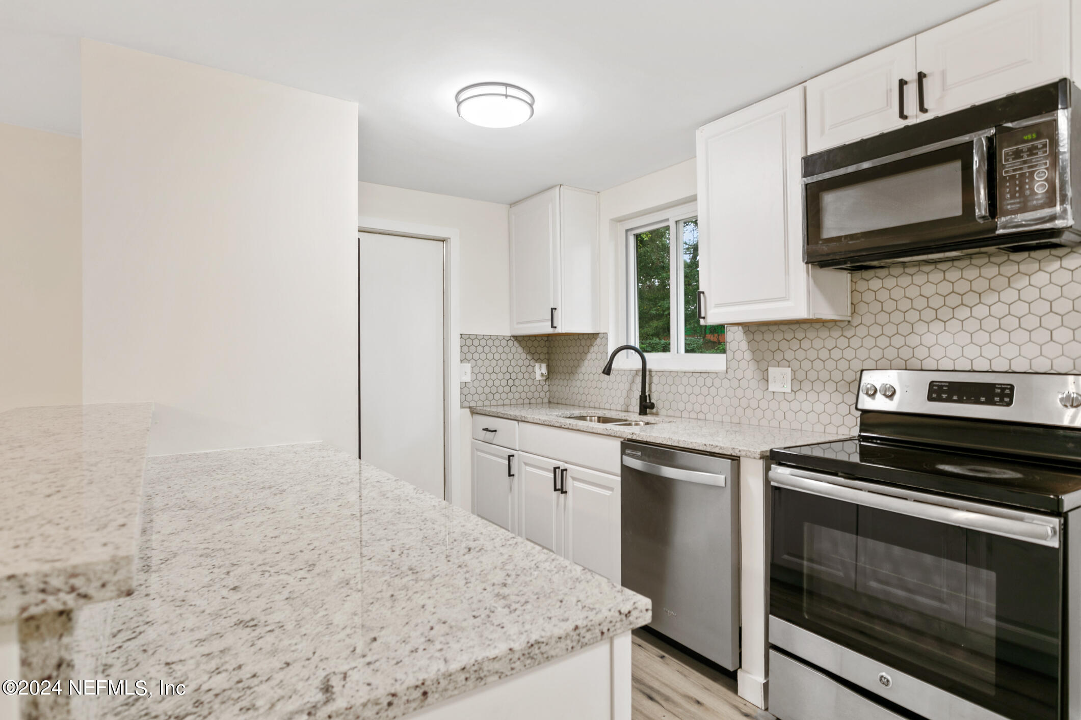 4216 Oriely Drive Jacksonville, FL 32210 - Photo 17 of 36 a kitchen with stainless steel appliances granite countertop a stove microwave and sink