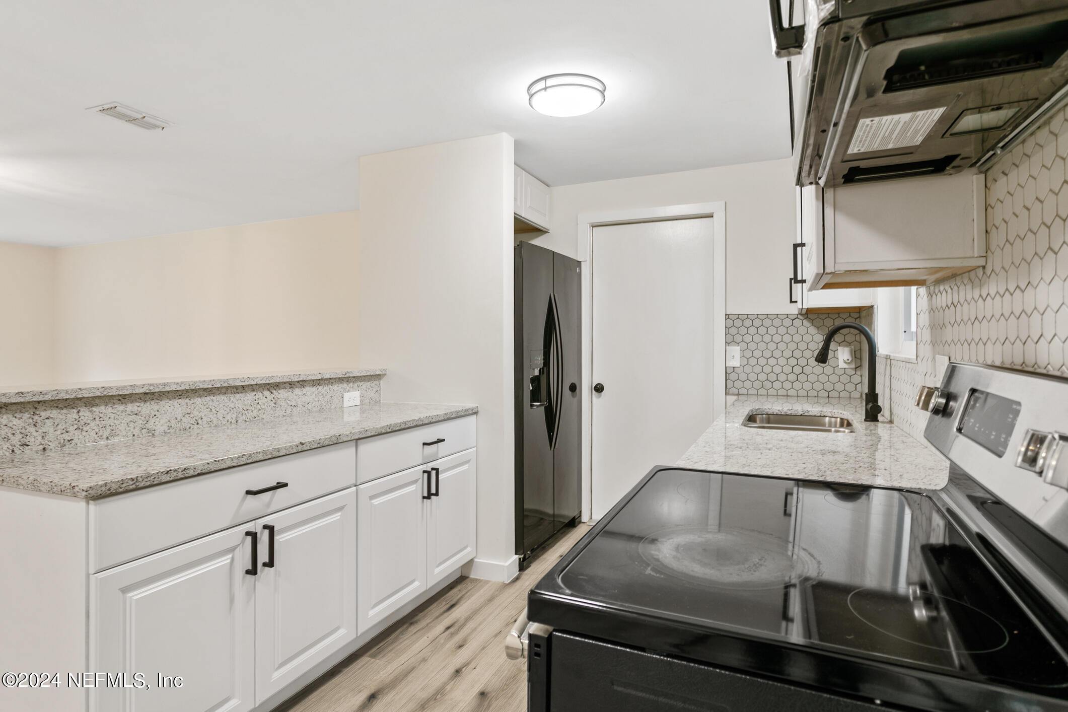 4216 Oriely Drive Jacksonville, FL 32210 - Photo 18 of 36 a kitchen with white cabinets and sink
