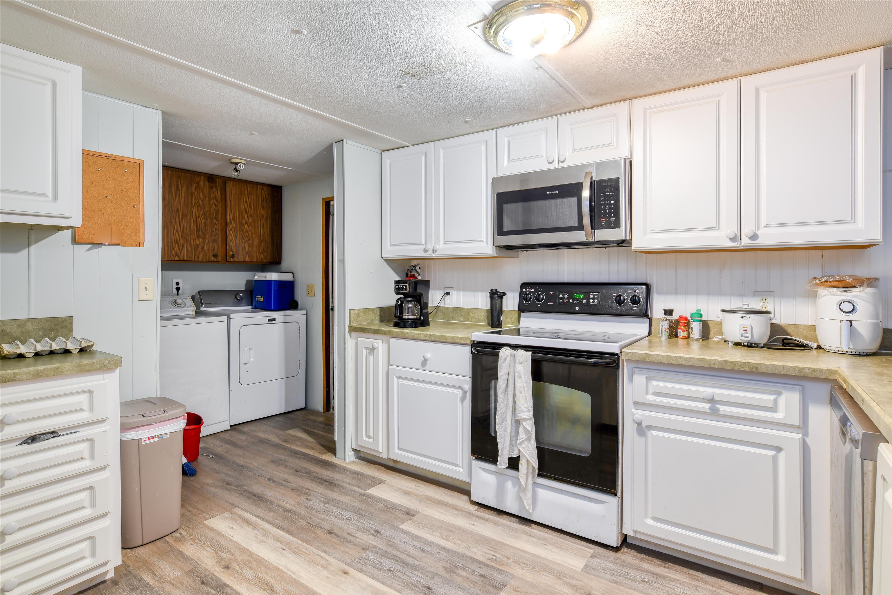 242 Basque Road St. Augustine, FL 32080 - Photo 10 of 20 a kitchen with stainless steel appliances granite countertop a stove top oven a sink dishwasher and white cabinets with wooden floor
