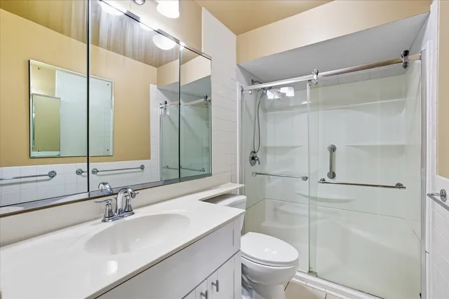 a bathroom with a sink toilet vanity and shower