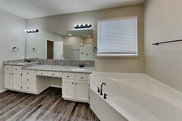 a bathroom with a granite countertop sink mirror bathtub and double