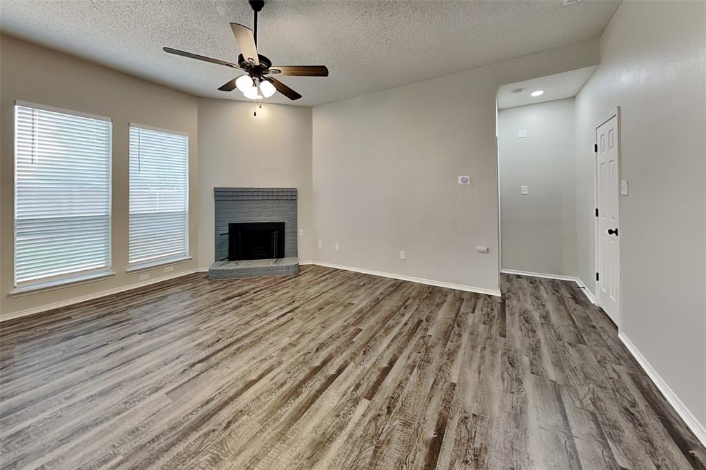2224 Red Maple Road Flower Mound, TX 75022 - Photo 2 of 22 a view of an empty room with wooden floor fireplace and a window