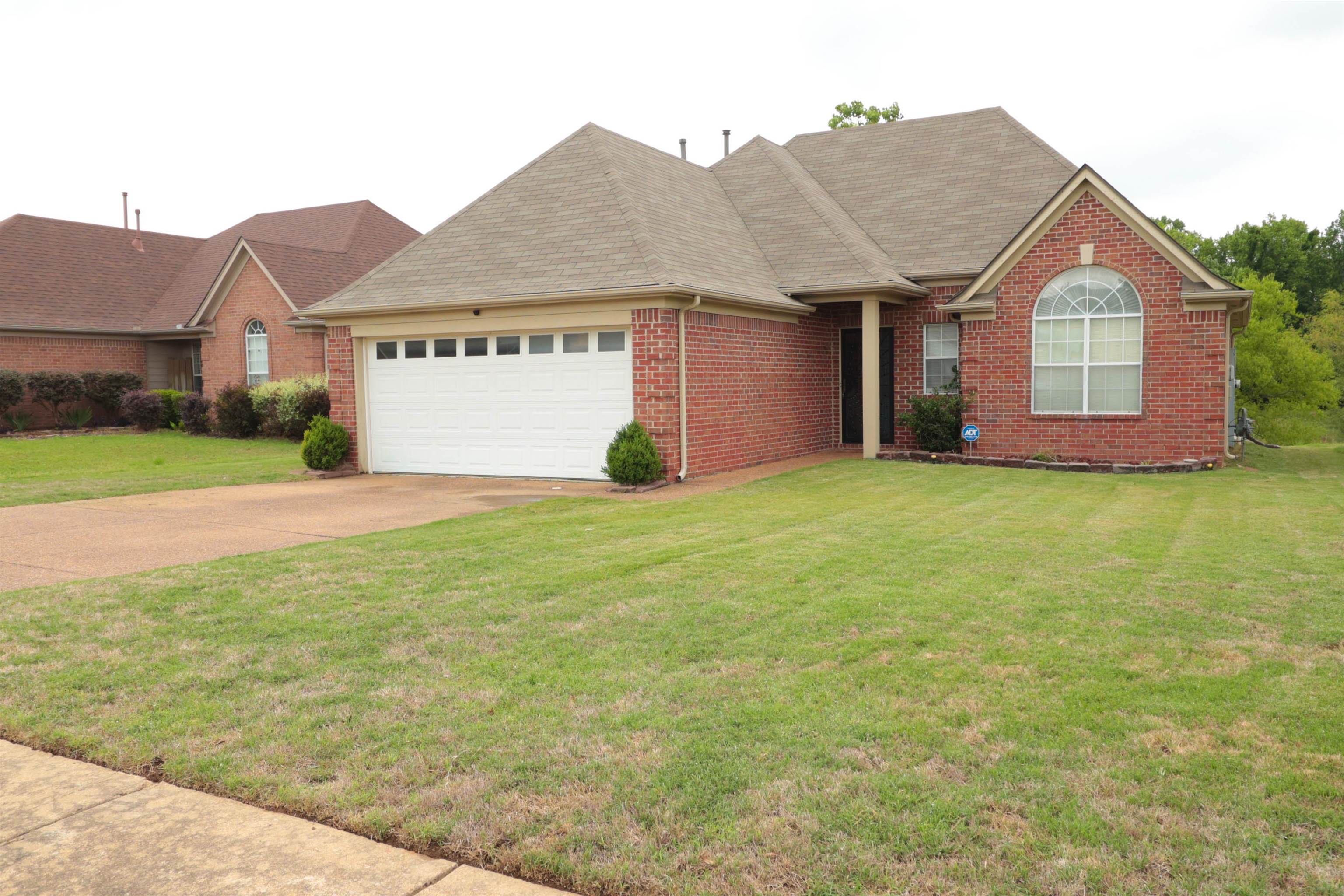 a view of a house with a yard and garage