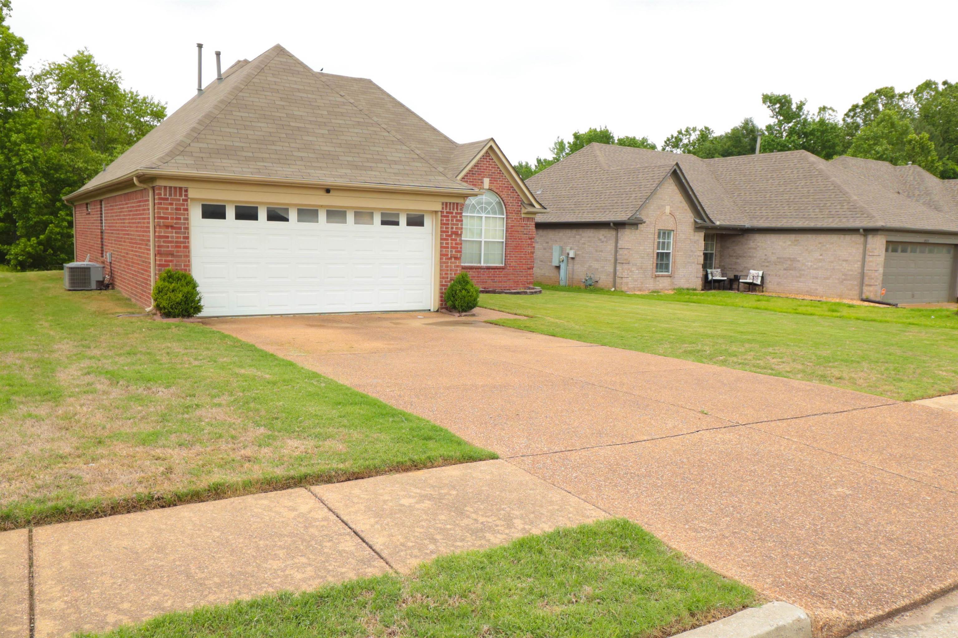 6916 Manslick Road Cordova, TN 38018 - Photo 2 of 17 a view of a big house with a big yard and large trees