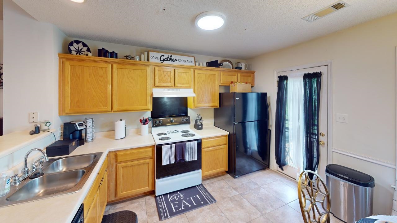 6916 Manslick Road Cordova, TN 38018 - Photo 5 of 17 a kitchen with stainless steel appliances granite countertop a sink stove and refrigerator