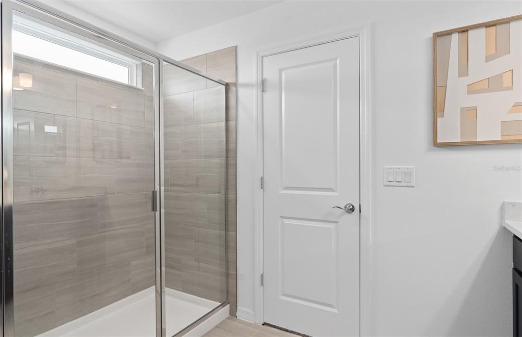 10382 Evening Horizon Street Orlando, FL 32829 - Photo 17 of 26 a bathroom with a glass shower door