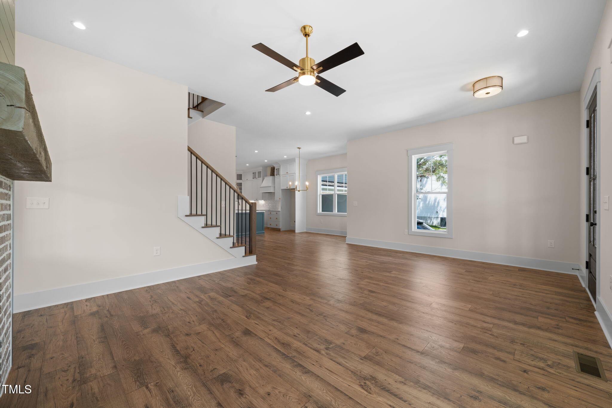 250 Pilot Ridge Road Zebulon, NC 27597 - Photo 6 of 43 an empty room with wooden floor a ceiling fan and windows