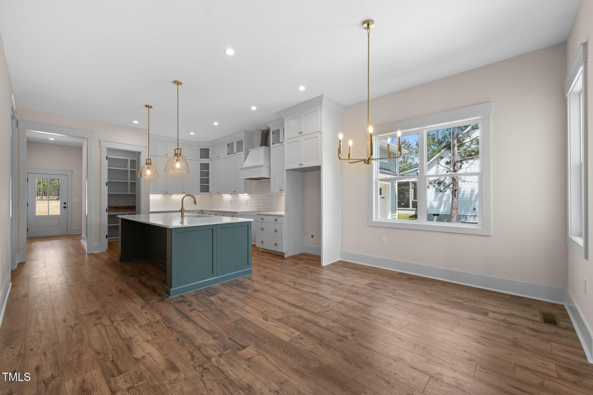 250 Pilot Ridge Road Zebulon, NC 27597 - Photo 7 of 43 a large kitchen with kitchen island a island wooden floor and stainless steel appliances