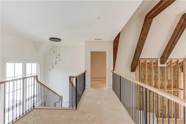 a view of a hallway with wooden floor and stairs