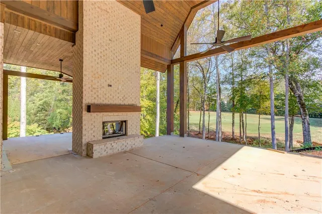 a view of an empty room with a fireplace and a window