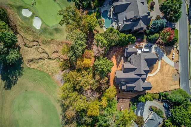 an aerial view of residential house with outdoor space and trees all around