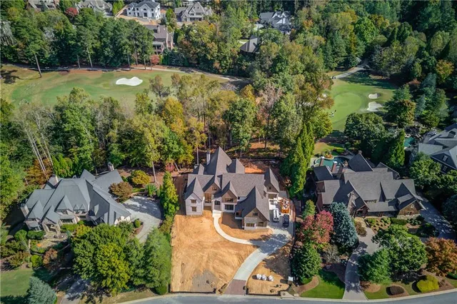 an aerial view of residential houses with outdoor space and trees