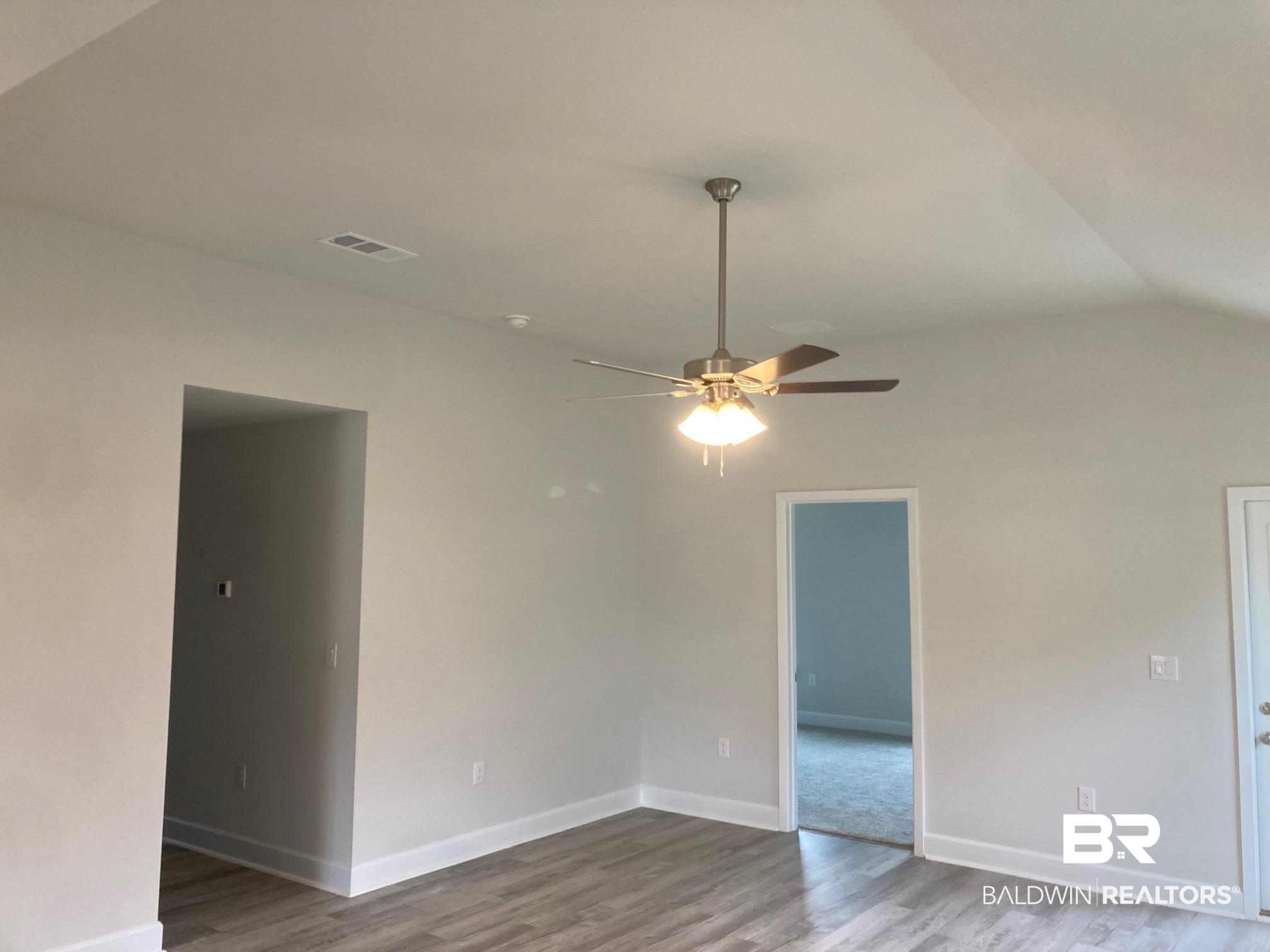 649 Revere Street Foley, AL 36535 - Photo 6 of 18 Spare room featuring lofted ceiling, baseboards, visible vents, a ceiling fan, and wood finished floors