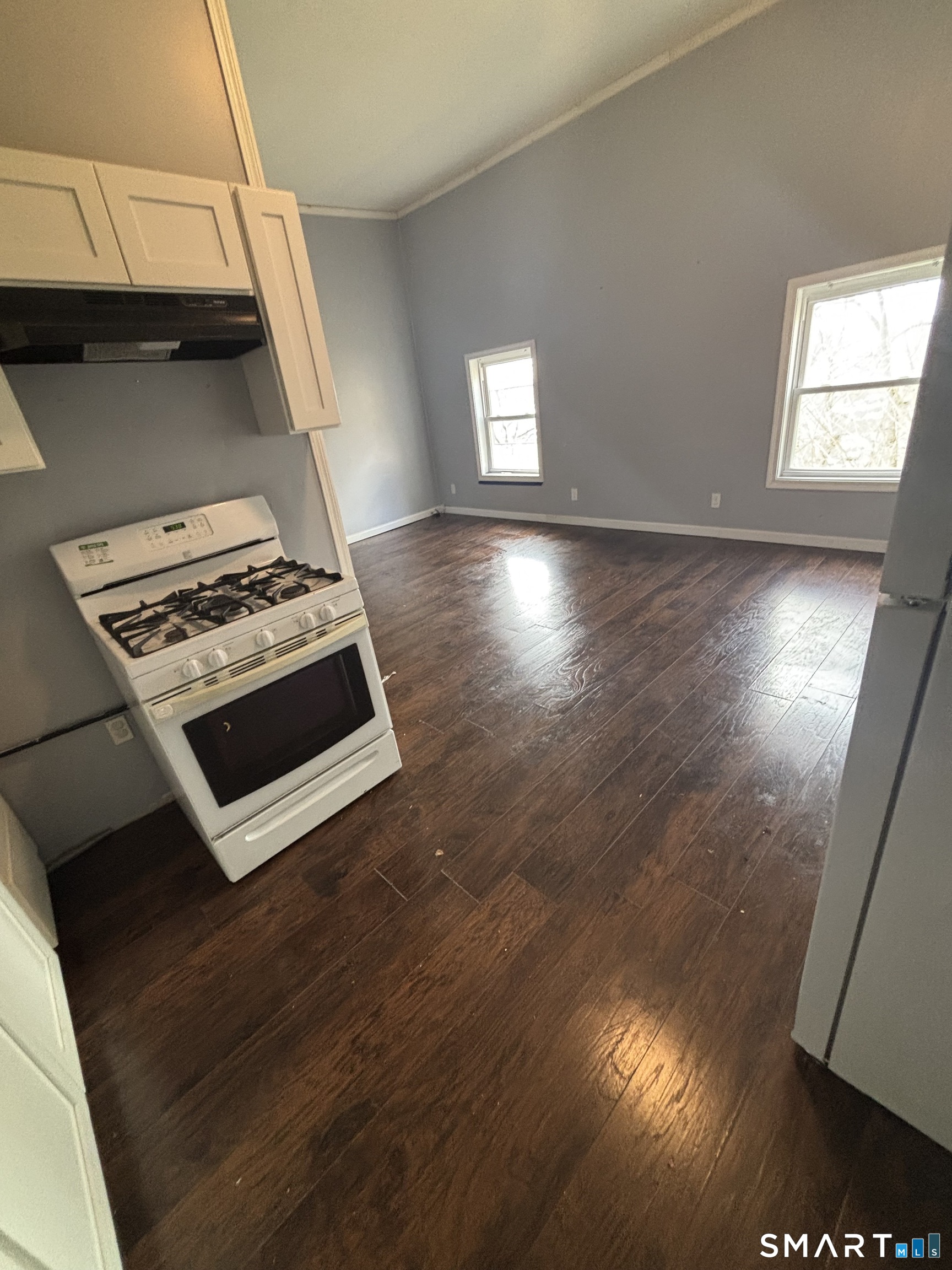 a kitchen with granite countertop a stove and a wooden floor