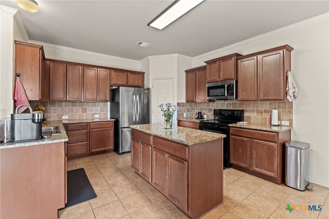 305 Brunswick Temple, TX 76502 - Photo 25 of 28 a kitchen with stainless steel appliances granite countertop a refrigerator stove microwave and sink