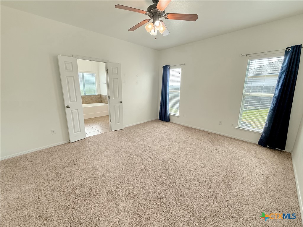 305 Brunswick Temple, TX 76502 - Photo 10 of 28 an empty room with chandelier fan and windows