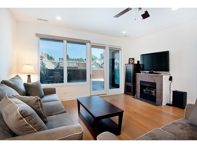 1842 West Irving Park Road, Unit 202 Chicago, IL 60613 - Photo 11 of 20 a living room with furniture a fireplace and a flat screen tv