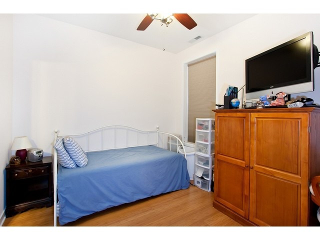 1842 West Irving Park Road, Unit 202 Chicago, IL 60613 - Photo 14 of 20 a bedroom with a bed and flat screen tv