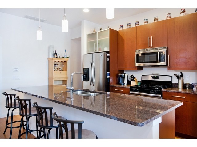 1842 West Irving Park Road, Unit 202 Chicago, IL 60613 - Photo 17 of 20 a kitchen with stainless steel appliances granite countertop a refrigerator a stove top oven and a sink