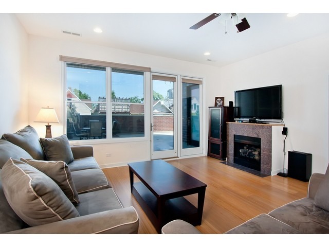 1842 West Irving Park Road, Unit 202 Chicago, IL 60613 - Photo 2 of 20 a living room with furniture a fireplace and a flat screen tv