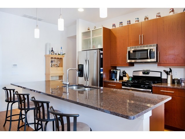1842 West Irving Park Road, Unit 202 Chicago, IL 60613 - Photo 4 of 20 a kitchen with stainless steel appliances granite countertop a refrigerator a stove top oven and a sink