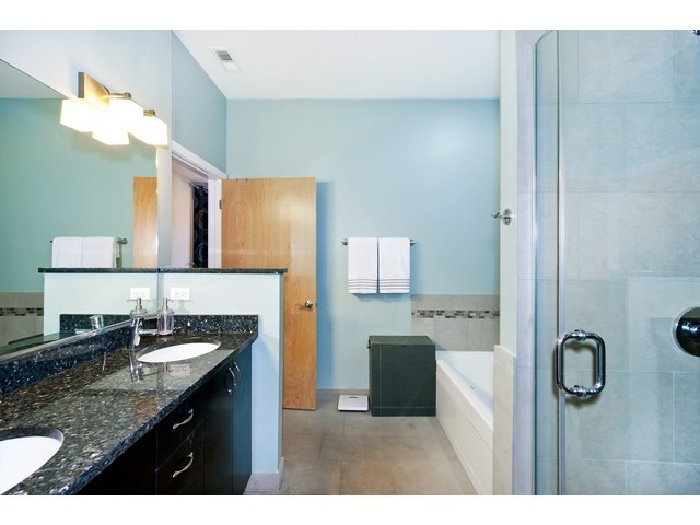 1842 West Irving Park Road, Unit 202 Chicago, IL 60613 - Photo 5 of 20 a bathroom with a granite countertop sink a mirror and a vanity