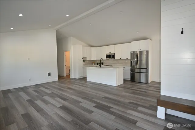 a view of a kitchen with a sink a refrigerator and a stove top oven