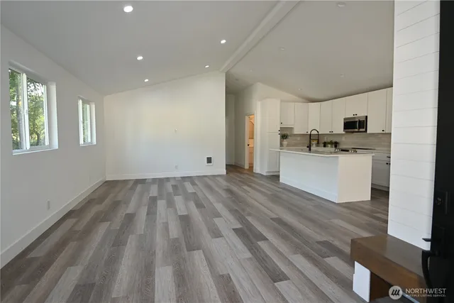 a view of a kitchen with wooden floor and electronic appliances