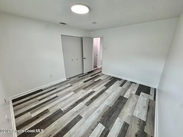 a view of a hallway with wooden floor and entryway
