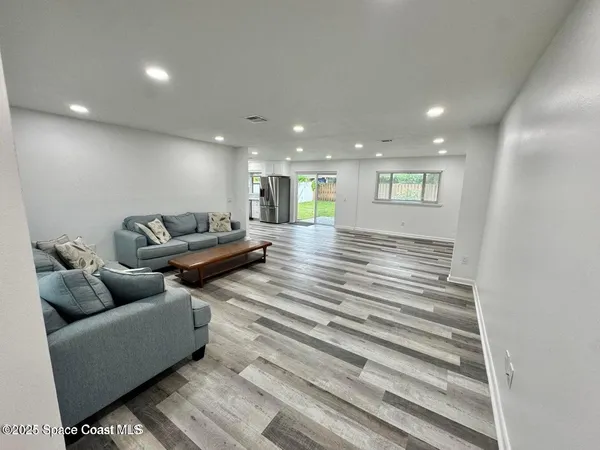 a living room with furniture and a ceiling fan