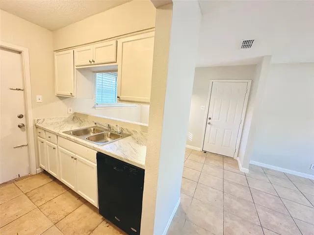 a kitchen with a stove sink and cabinets