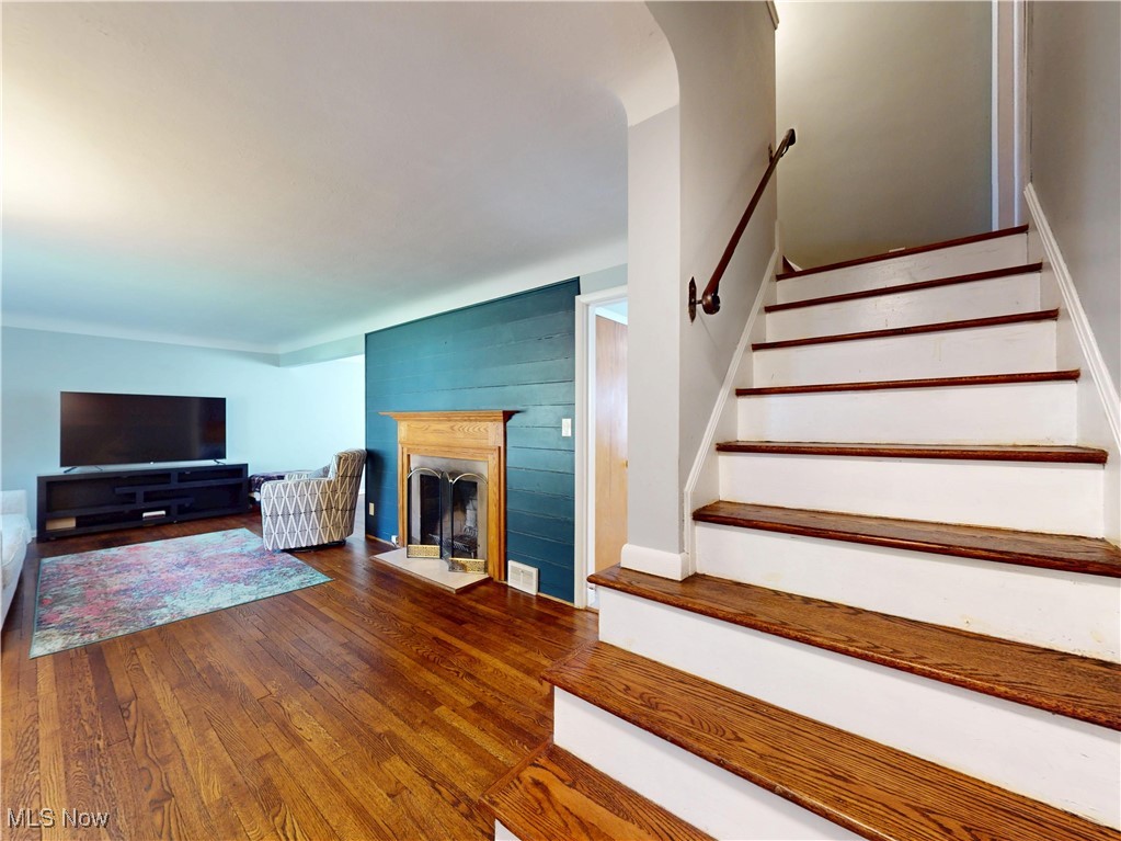 1025 Professor Road Cleveland, OH 44124 - Photo 11 of 34 Staircase featuring wood-type flooring and a fireplace