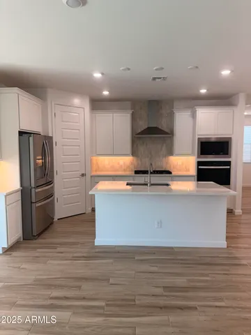 a kitchen with stainless steel appliances granite countertop a stove a sink and a refrigerator