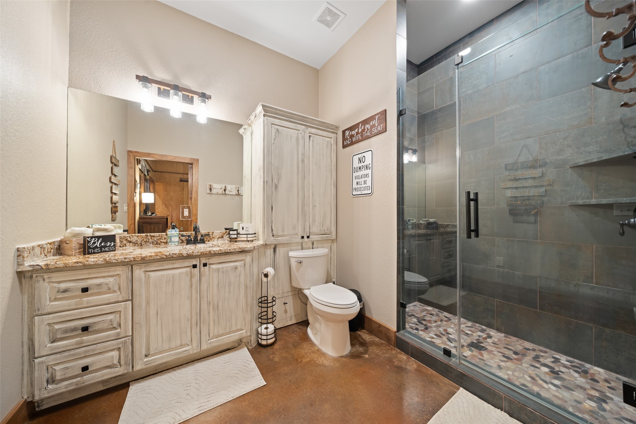 1402 Eagle Ferry Road Anahuac, TX 77514 - Photo 39 of 48 Full bath includes granite counters, a framed mirror, and a walk-in shower with river rock flooring and upgraded tile surround.