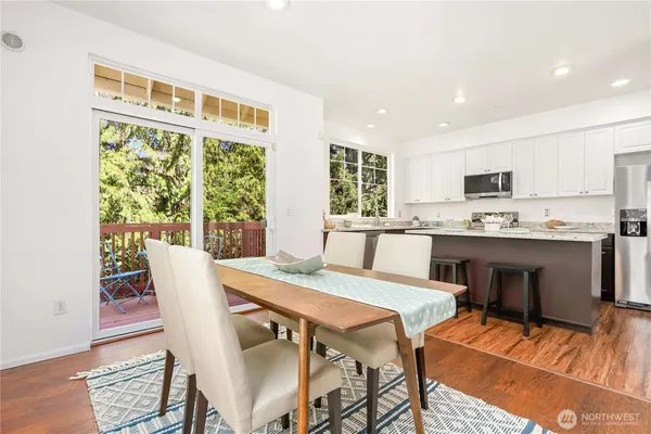a kitchen with a table chairs refrigerator and cabinets