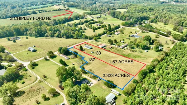 a view of an swimming pool with a yard and plants