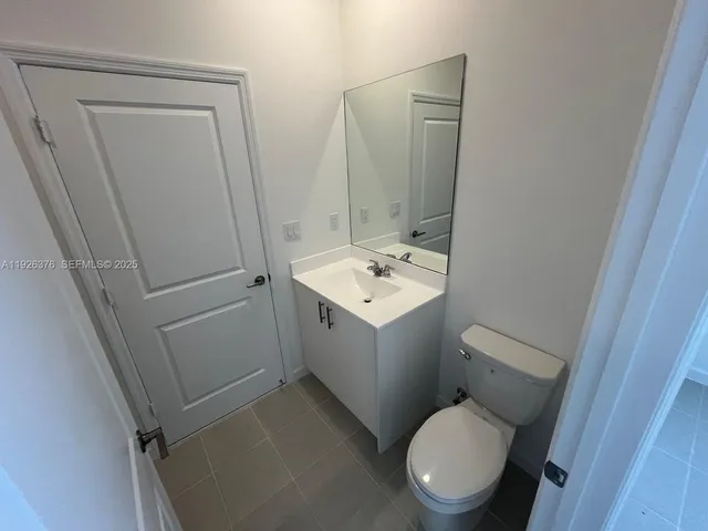 a white toilet sitting next to a white sink and vanity