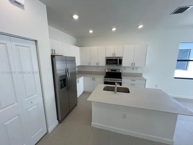 a kitchen with white cabinets and stainless steel appliances