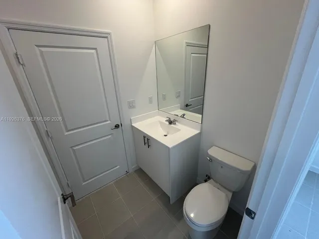 a white toilet sitting next to a white sink and vanity