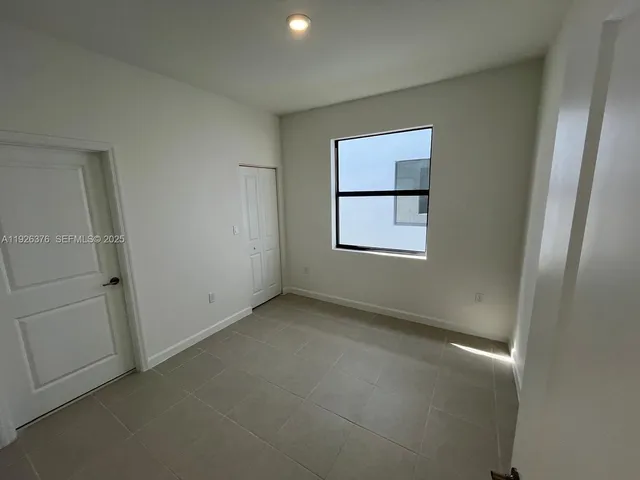 an empty room with windows and closet