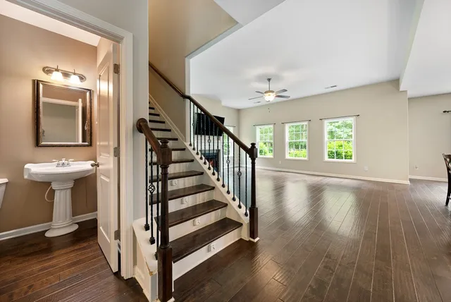 a view of a hallway with wooden floor and staircase