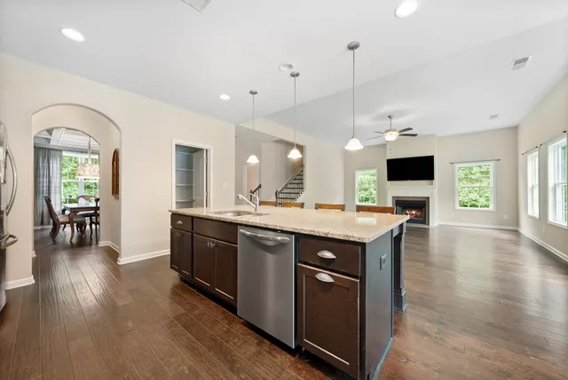 a kitchen with stainless steel appliances granite countertop wooden floors and view living room