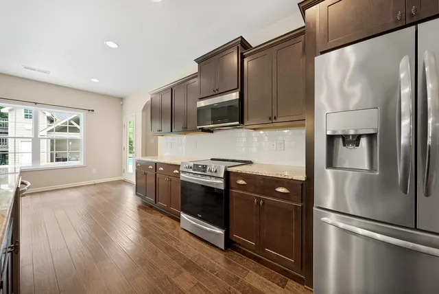 a kitchen with stainless steel appliances a refrigerator and a stove top oven