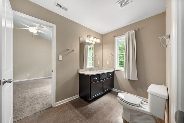a bathroom with a granite countertop sink toilet and shower